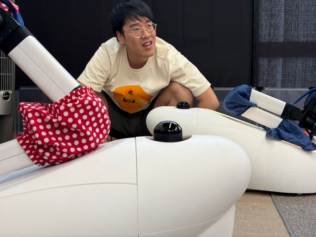 A person crouches between two white Goose prototypes.
