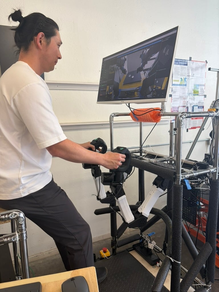 A person operates a control rig while watching a monitor.