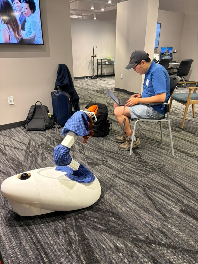 A Goose prototype stands on patterned carpet beside a seated person.
