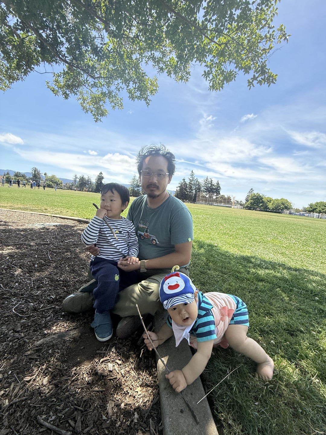 Humphrey Hu outdoors with two children