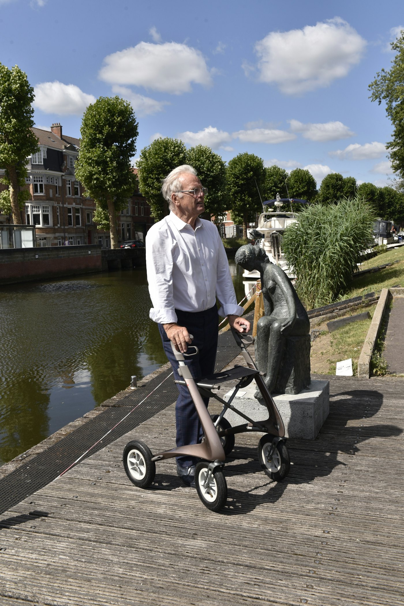 A woman walking along a canal with her walker