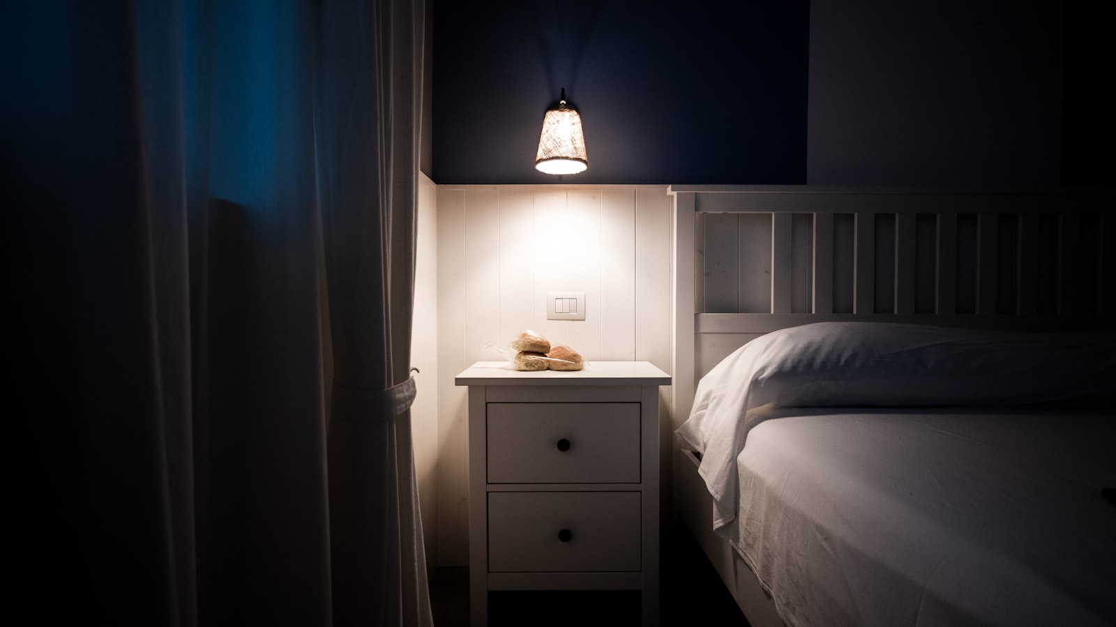 A bedside lamp glowing in a quiet bedroom at night