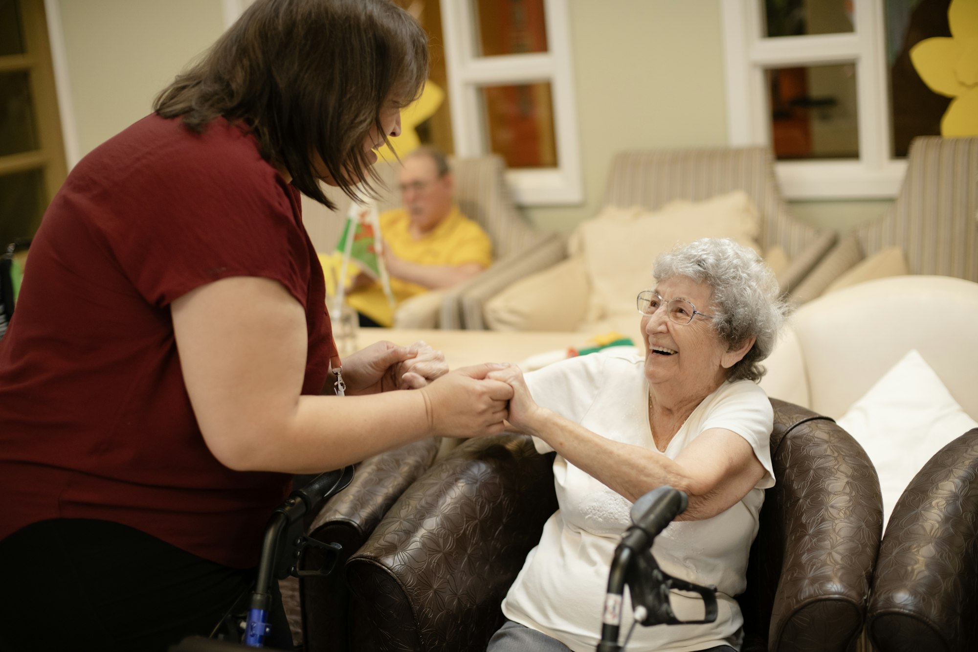 A caregiver walking beside a woman using her walker