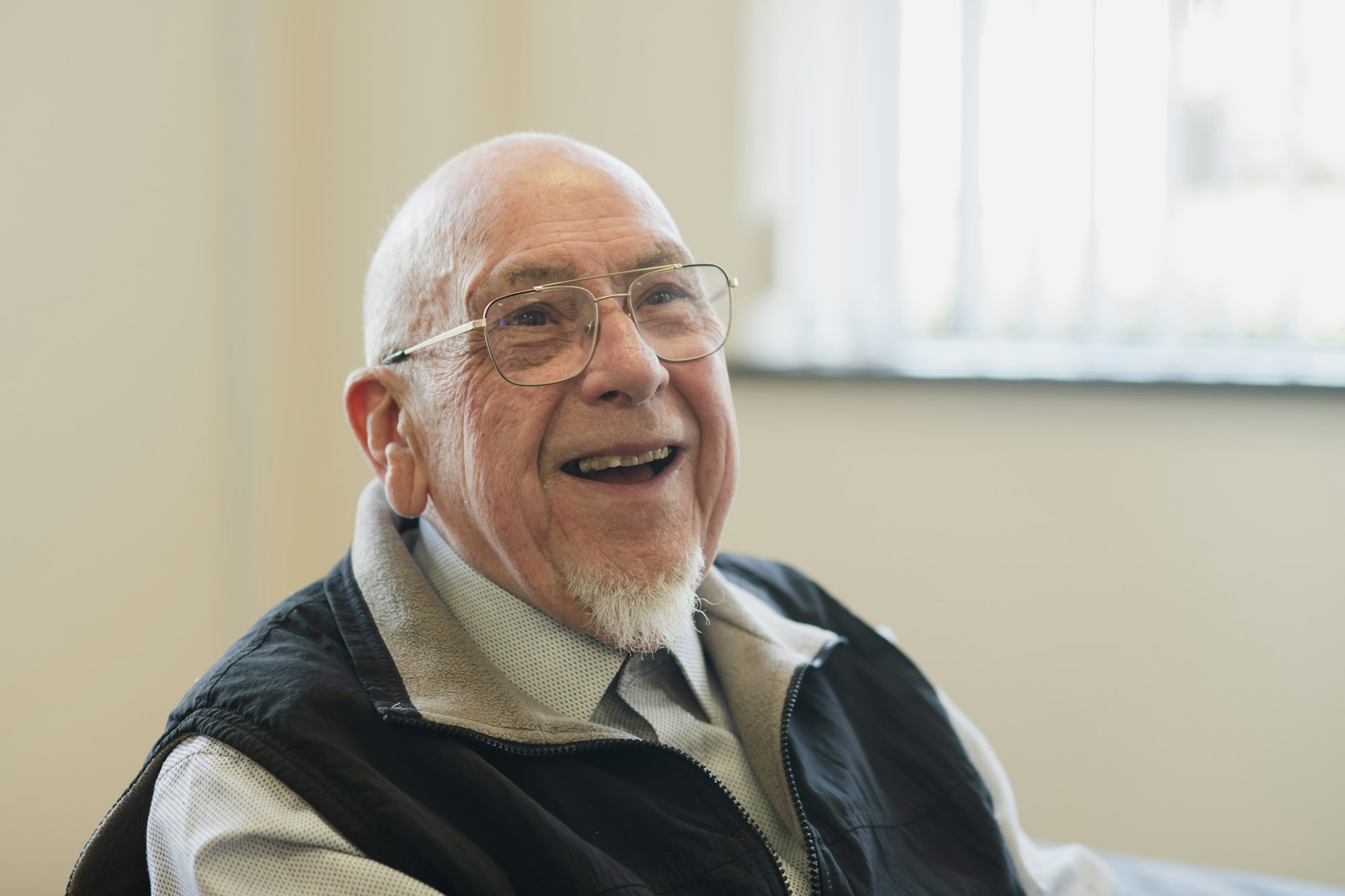 An older man mid-laugh, warm and direct