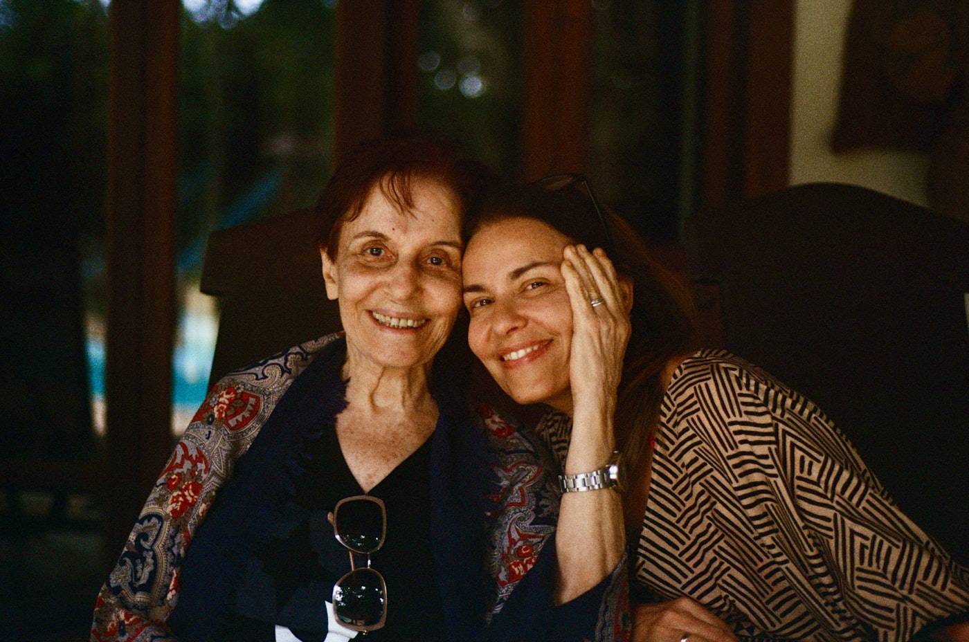 A mother and her adult daughter embracing, both smiling