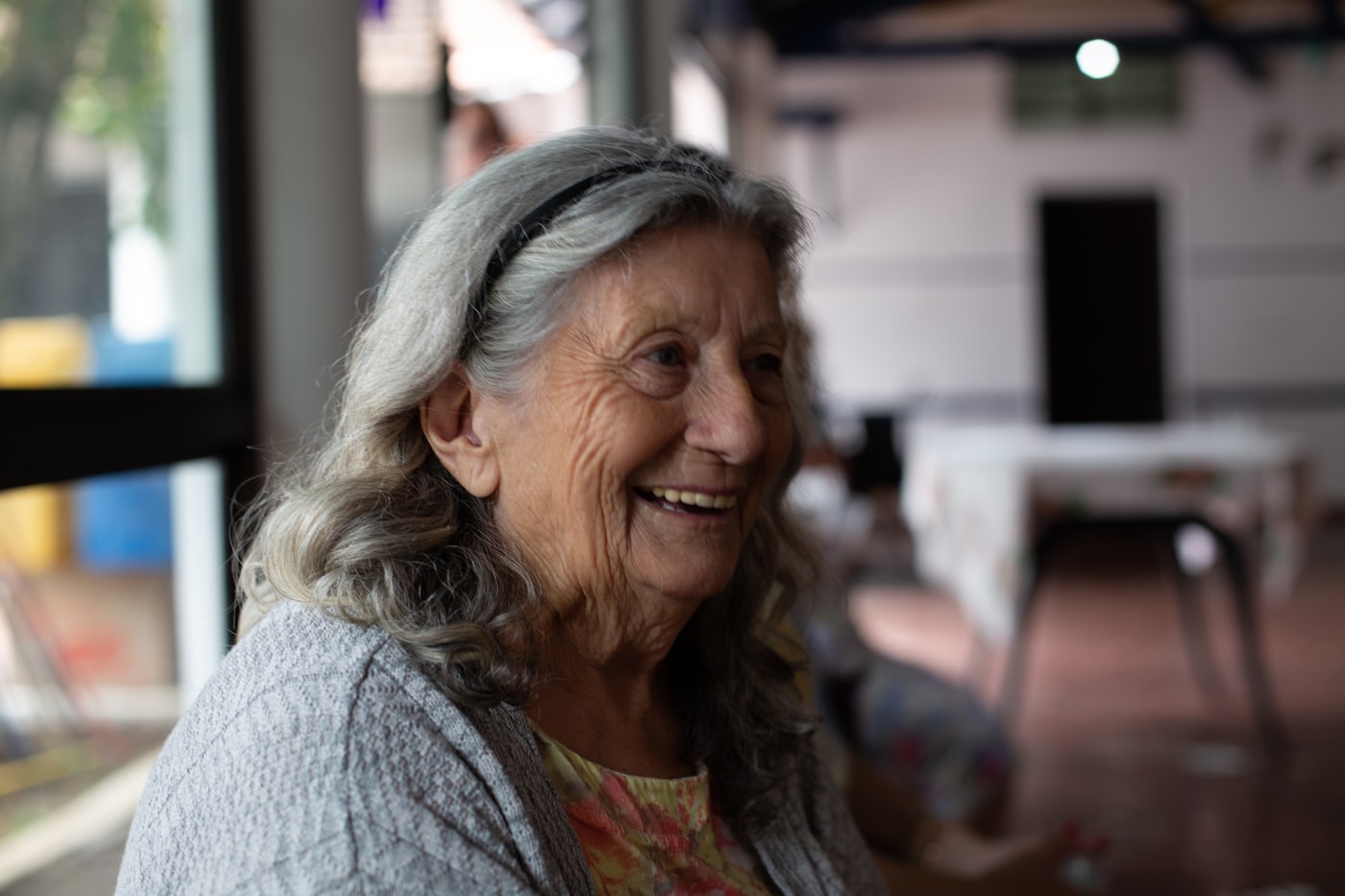 An older woman laughing in warm golden-hour light